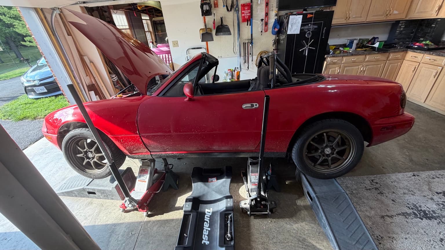 Mazda Miata raised for underbody and suspension inspection